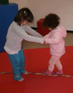 2016-17 un anno intenso di progetti di Circo nelle scuole (bambine che si tengono per mano)